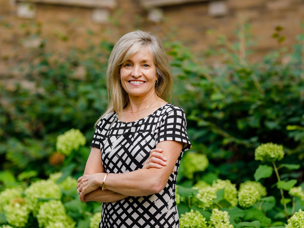 Dr. Nancy Whitmore's portrait taken in front of a garden.