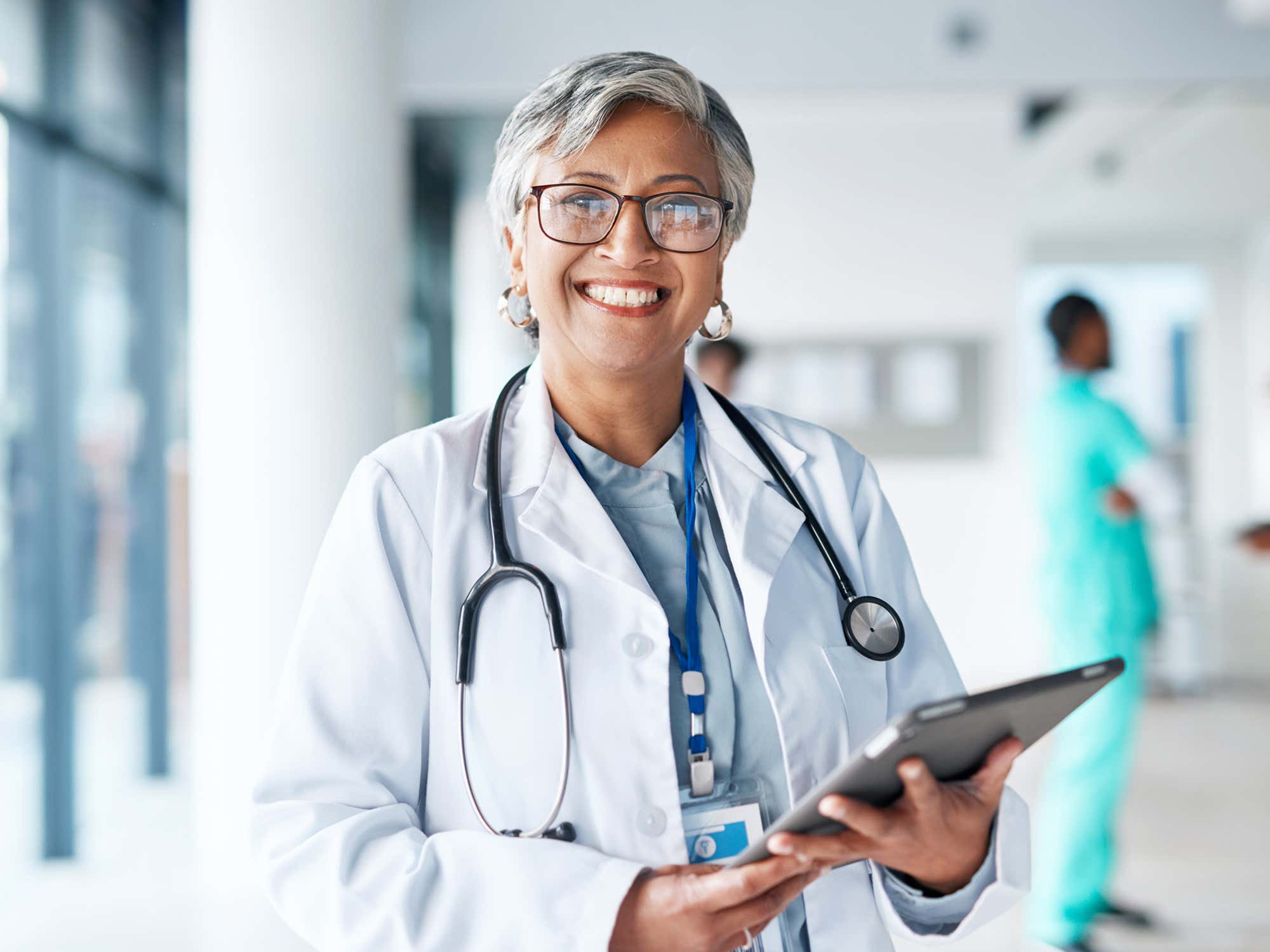 Portrait of a female doctor standing holding a tablet.