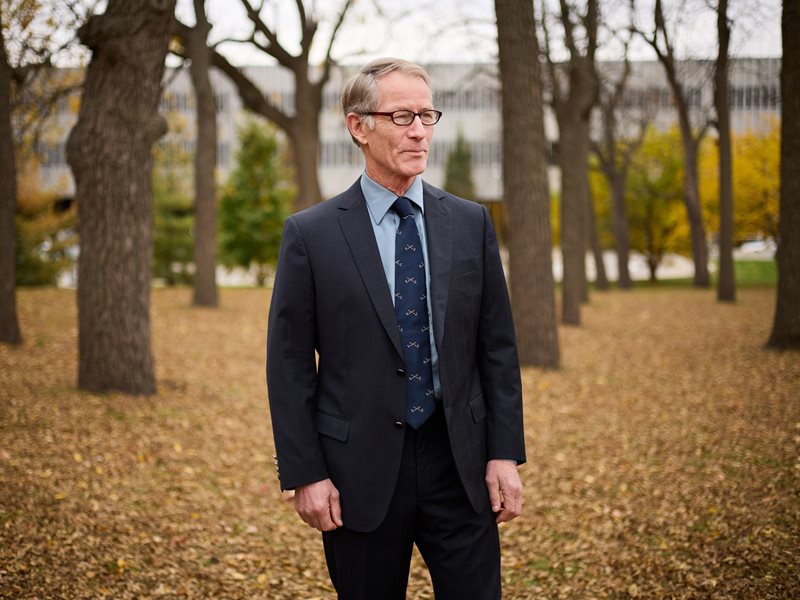 Portrait of Dr. John Rawlinson taken outside in between trees.