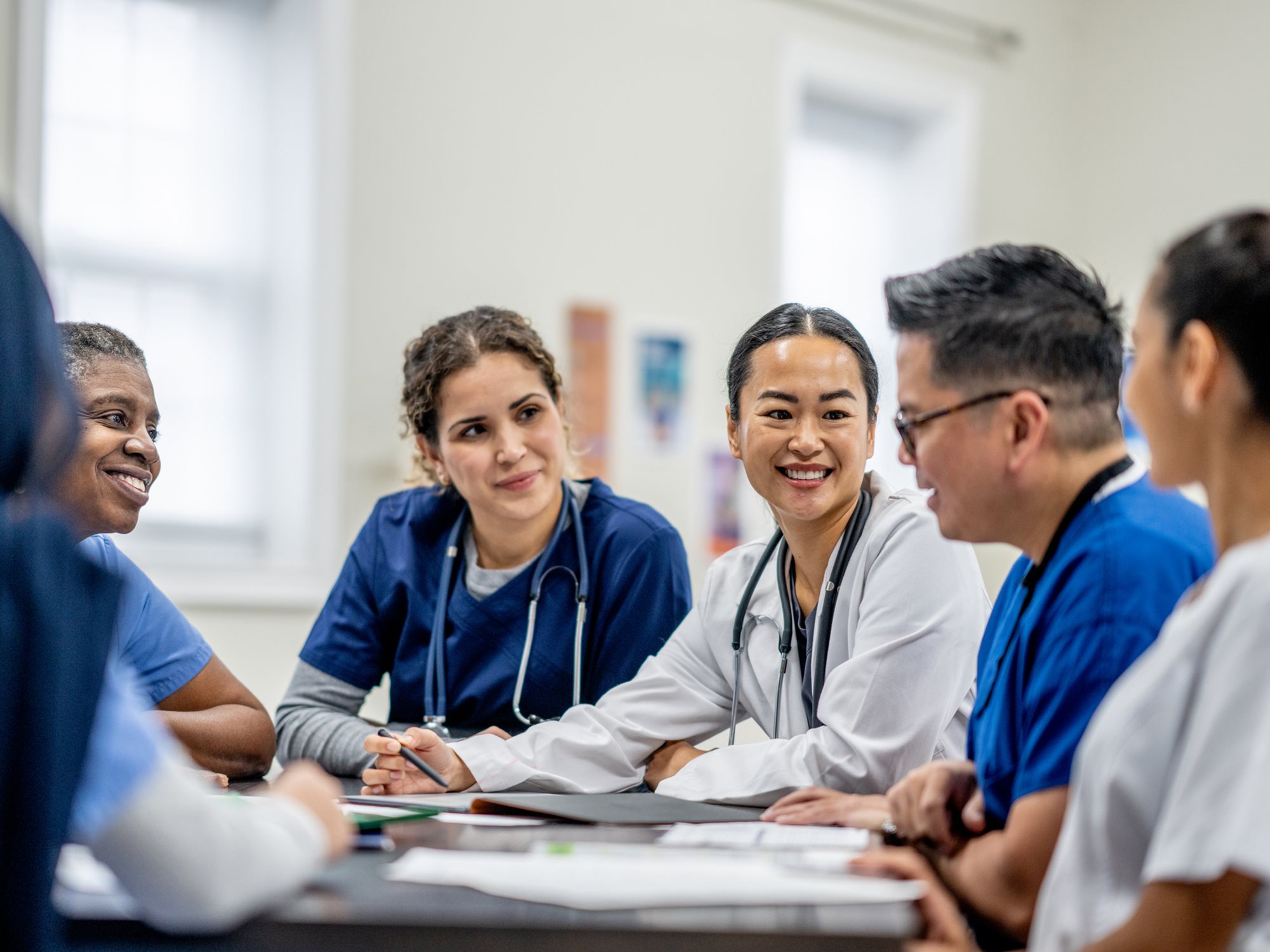 A group of 5-6 physician assistants sitting around a table.