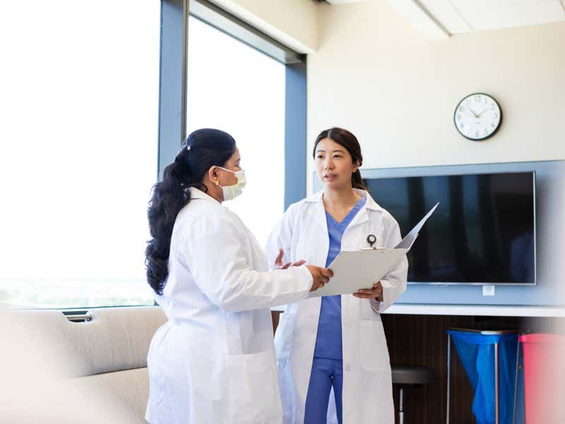  Two Female Doctors Discussing Patient Healthcare in Hospital.