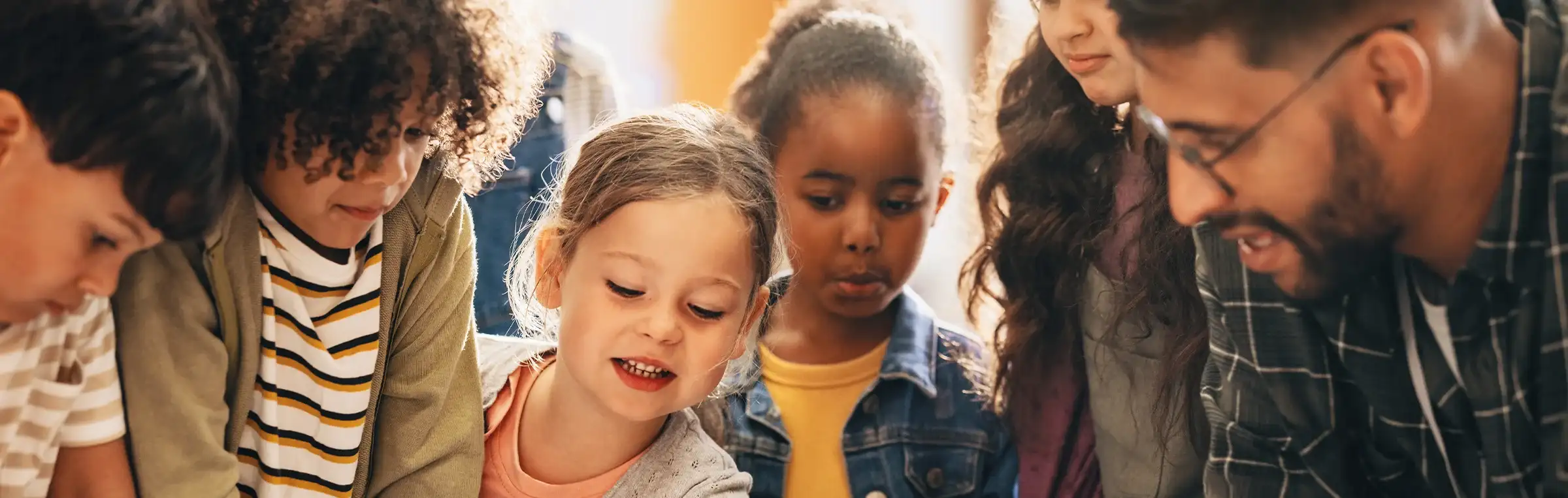 Photo of a teacher engaging with a diverse group of students.
