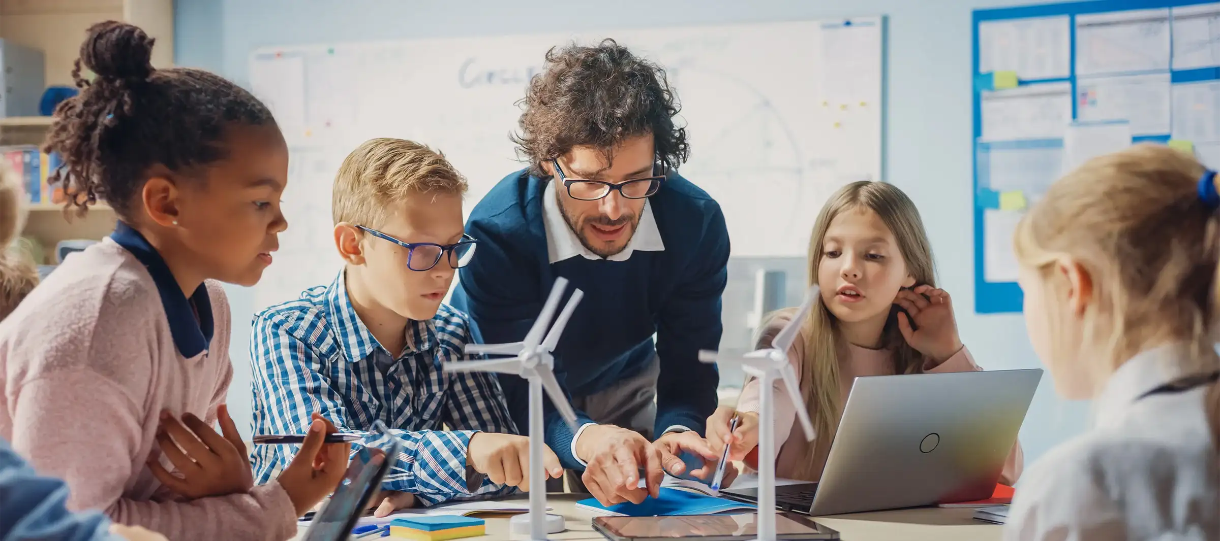 Photo of a teacher engaging with a diverse group of students.