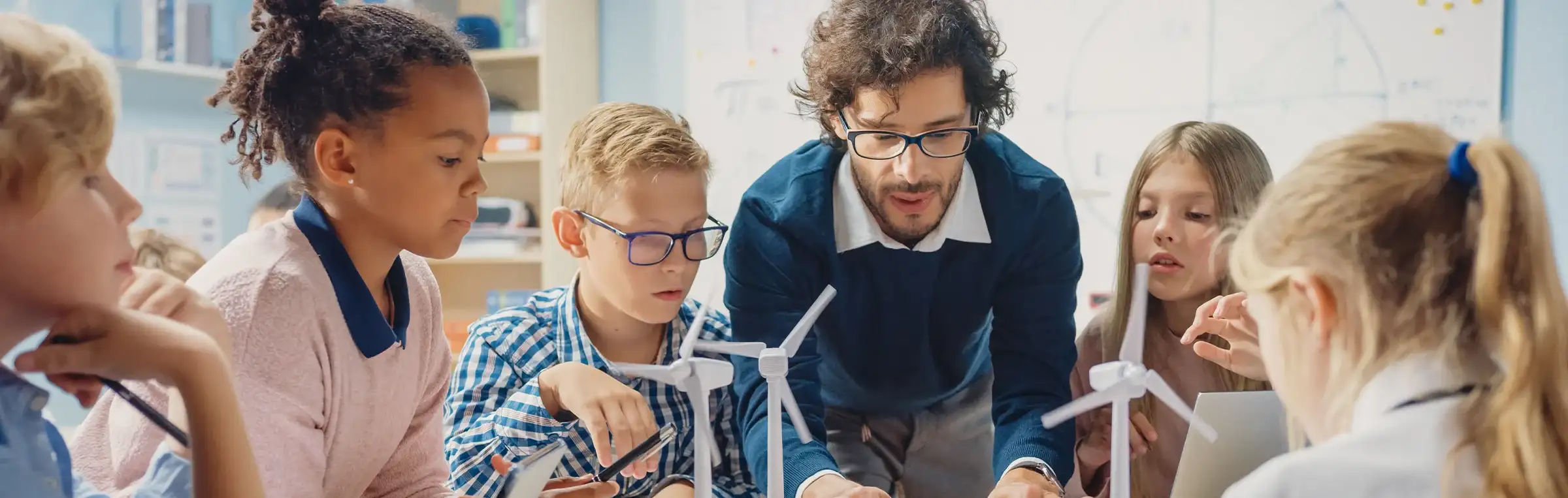Photo of a teacher engaging with a diverse group of students.