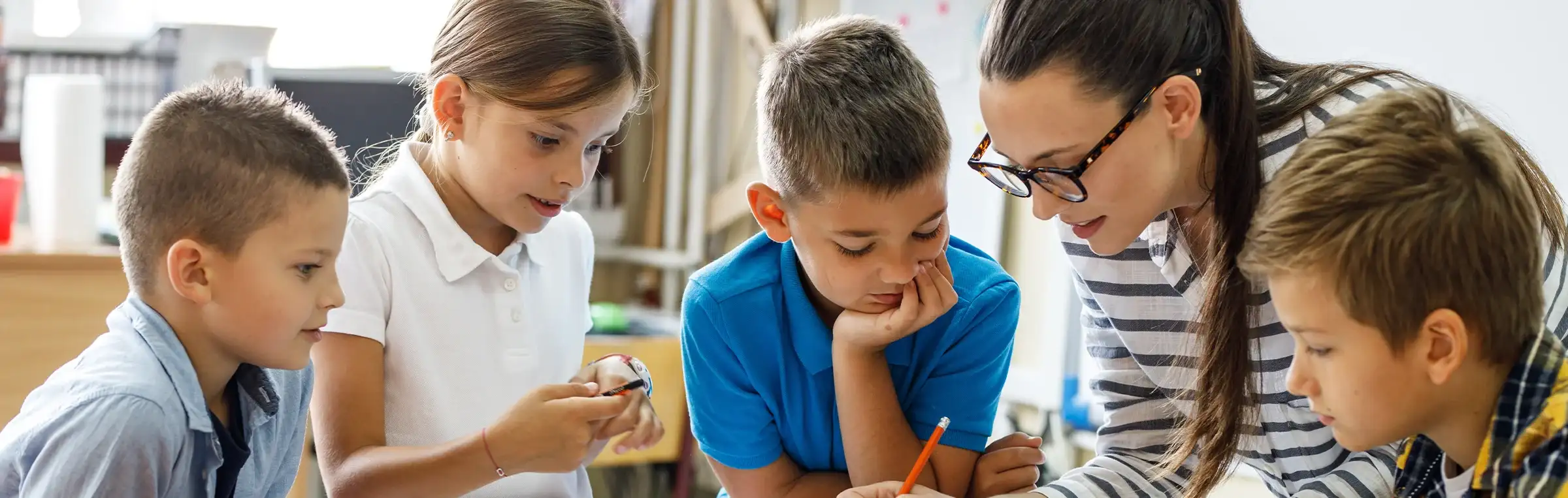 Photo of a teacher engaging with students on a project.