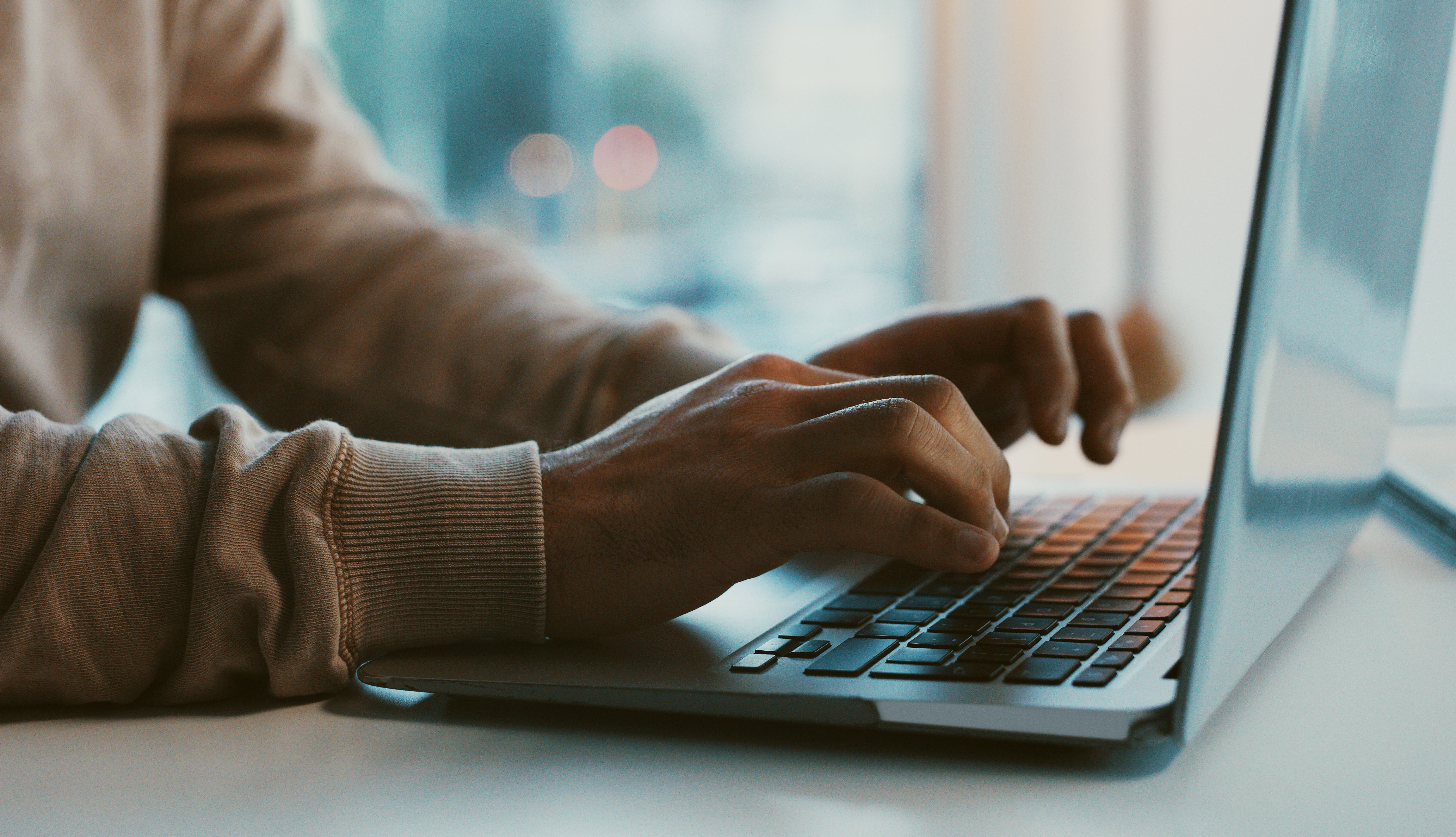 Close up of a person typing on a laptop.